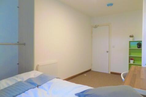 Bright, simply furnished bedroom with a comfort...