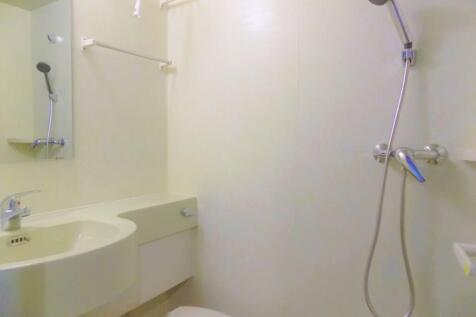 Bright, compact bathroom with a wall-mounted si...