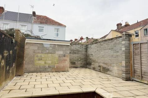 Paved enclosed rear yard with high brick and bl...