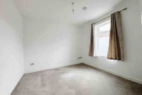 Bright, neutral bedroom with a large window, ne...