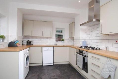 Bright modern kitchen with neutral cabinetry, w...