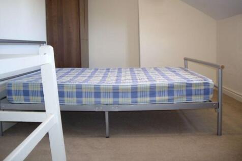 Simple, tidy bedroom with a metal single bed an...