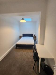 A cozy single bedroom featuring a comfortable b...