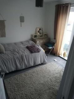 Cozy double bedroom with a neutral palette, sof...