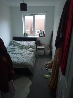Bright, simply furnished bedroom with a double ...