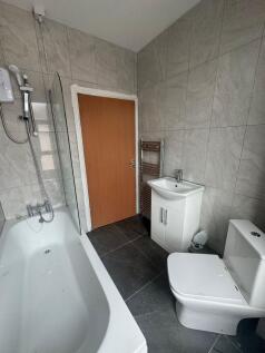 Contemporary tiled bathroom with a fitted bath ...