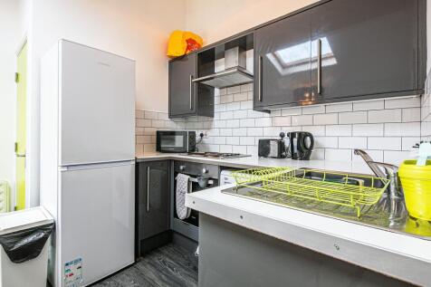 Modern galley kitchen with dark gloss cabinets,...