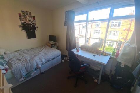 A cozy student bedroom featuring a single bed, ...