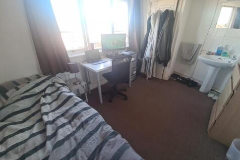 A cozy bedroom featuring sunlight coming throug...