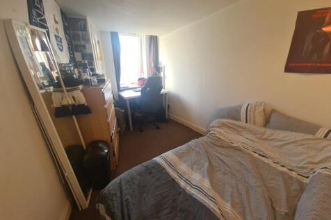 A cozy bedroom with a double bed, a desk, and a...