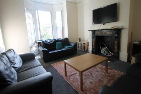 A spacious, well-lit living room featuring comf...