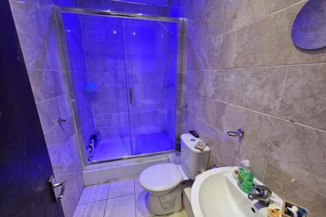 A modern bathroom featuring a large shower encl...