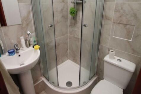 A modern, clean bathroom featuring a large show...