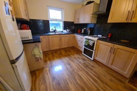 A well-lit kitchen with wooden cabinets, modern...