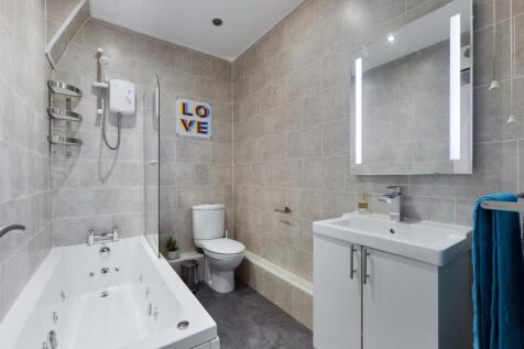 A spacious and modern large bathroom featuring ...