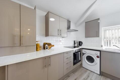 A modern and clean kitchenette with ample stora...