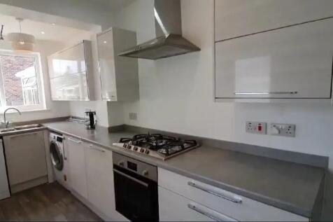 A modern kitchen featuring sleek cabinetry, a s...