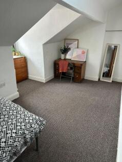 A cozy single bedroom with white textured walls...