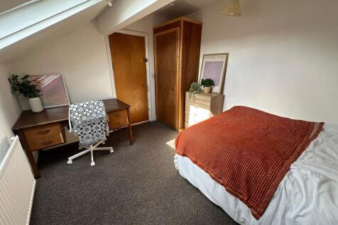 A cozy bedroom featuring a comfortable double b...