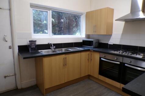 A modern and tidy kitchenette with ample natura...