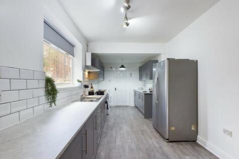 A spacious and modern kitchen with ample natura...