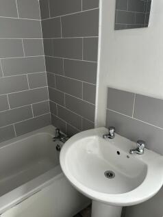 A clean bathroom featuring a white sink with du...