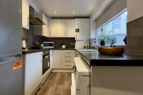 A modern and clean kitchenette with ample natur...