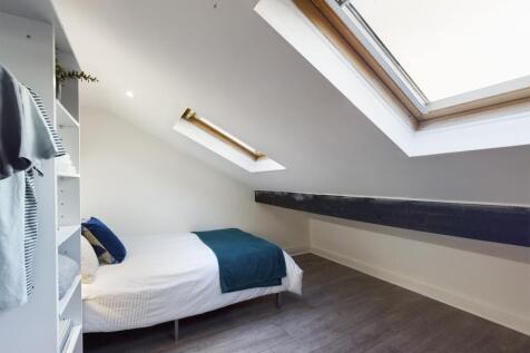 A bright and inviting double bedroom with styli...