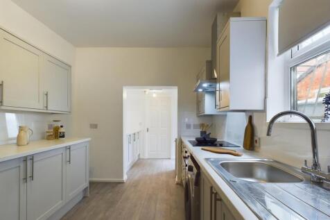 Modern kitchen featuring sleek cabinetry, ample...