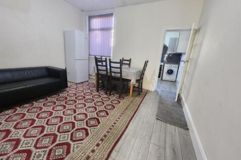 A spacious and well-lit living room featuring a...