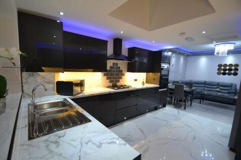 Contemporary open-plan kitchen with glossy blac...