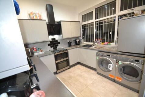 Modern galley-style kitchen with sleek grey cab...