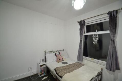 Cozy single bedroom with a neatly made bed, sof...