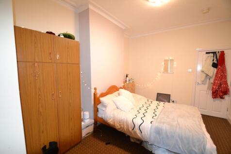 Cozy double bedroom with a wooden bedframe, war...