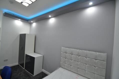 A modern bedroom featuring a plush upholstered ...