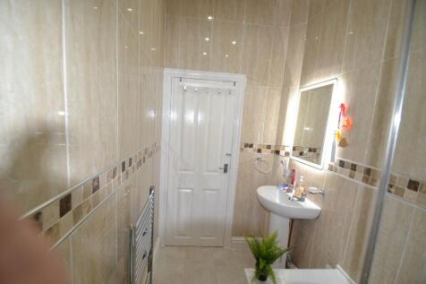 Bright and clean bathroom featuring beige tiled...