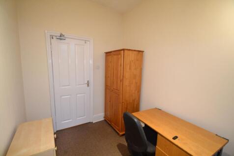 A tidy, modest bedroom featuring a wooden wardr...