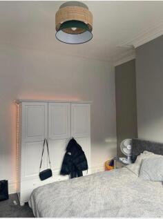 A cozy bedroom featuring a neatly made bed, a l...