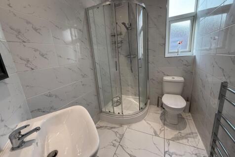 Bright, modern bathroom with a corner glass sho...