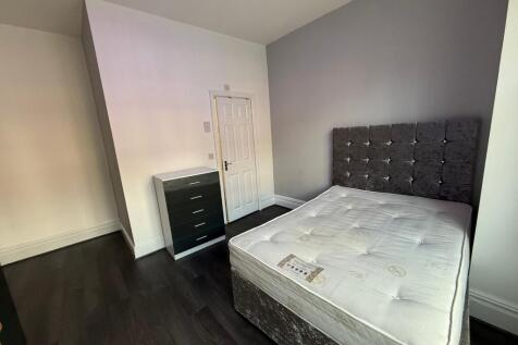 Bright, modern double bedroom with a plush upho...