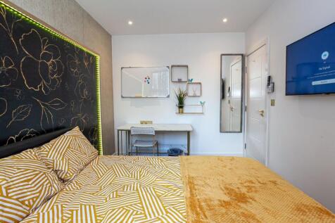 A bright and inviting double bedroom with styli...