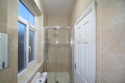 Bright and clean bathroom with beige tiled wall...