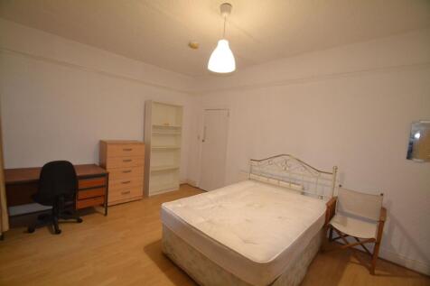 A modest bedroom featuring a double bed, a smal...