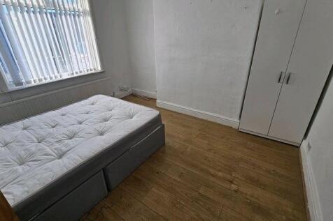 A small, tidy room with a single bed and a ward...