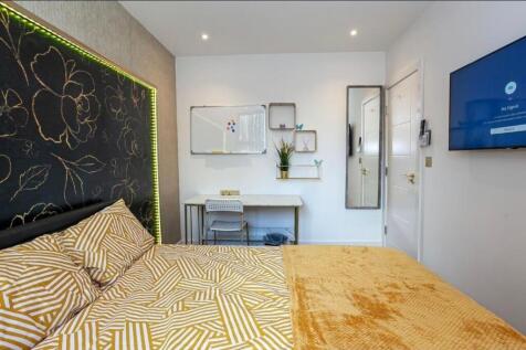 Bright, modern bedroom with patterned bedding, ...