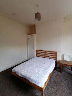 Bright, simply furnished bedroom with a wooden ...