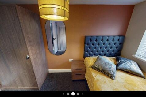 Well-presented bedroom with a tufted upholstere...