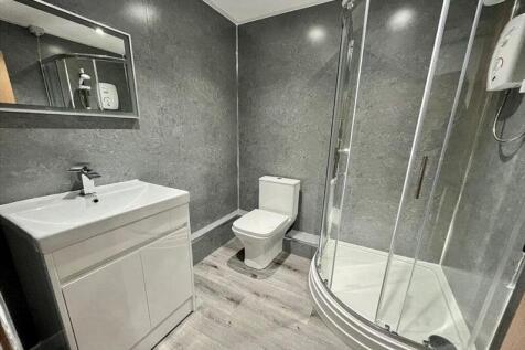 Modern bathroom with a corner glass shower encl...
