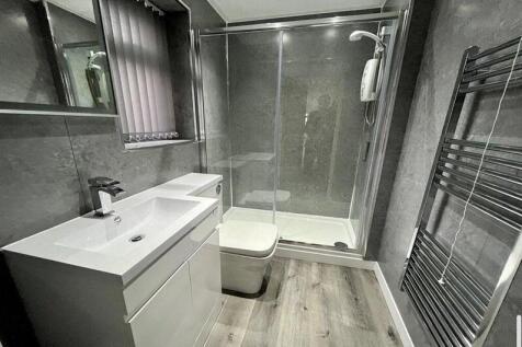 Modern bathroom with a large glass shower enclo...