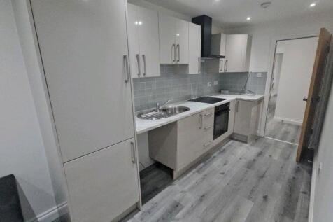 Modern galley kitchen with sleek white cabinetr...